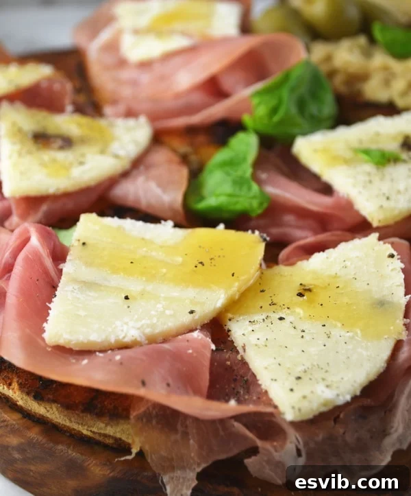 Crostini Three Ways Recipe - Prosciutto, Pecorino with Truffles & Honey Crostini! Gourmet crostini with slices of prosciutto, truffled pecorino cheese, and a drizzle of honey, ready to serve.