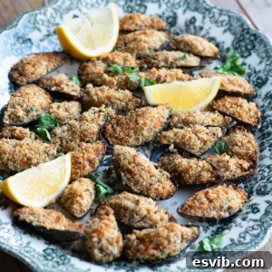 A cropped square image of mussels generously topped with crispy breadcrumbs, beautifully arranged on a serving platter.