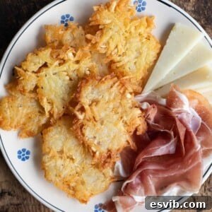 A close up cropped image of Tortei di Patate fritters on a plate with meat and cheese, ready to be enjoyed as a classic Italian appetizer.