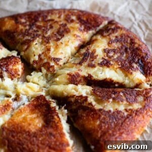 A close up of a cheesy potato cake cut into slices (frico).