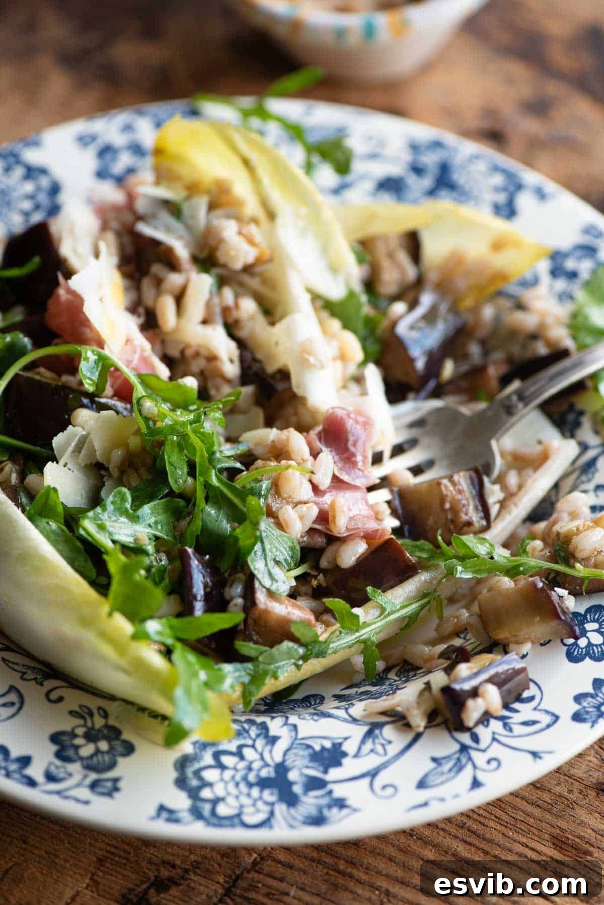 Italian Harvest Farro with Prosciutto 6 A close up of a eggplant and farro salad made with bitter greens and pine nuts, showcasing the textures and vibrant colors.