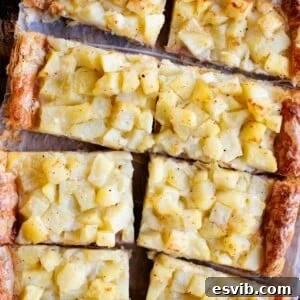 A cropped overhead image of a puff pastry potato tart cut into slices.