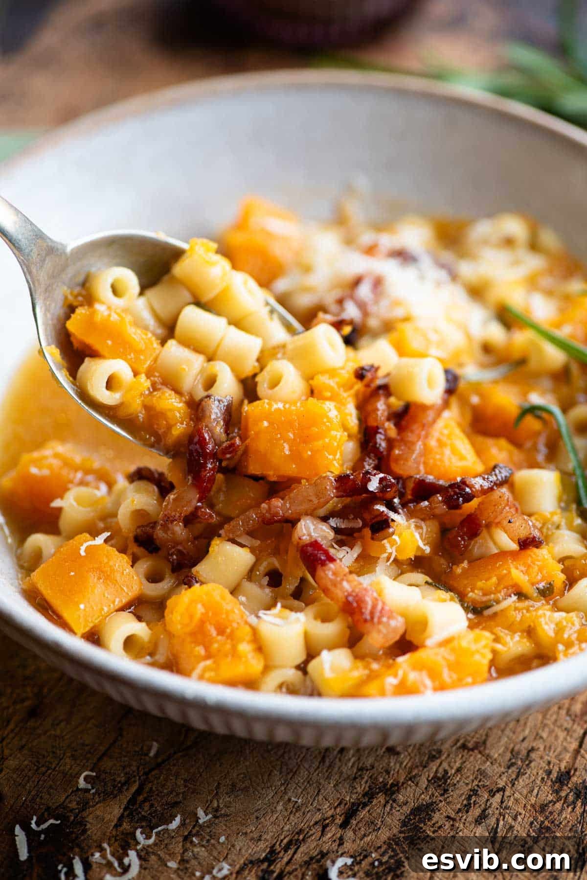 Velvety Butternut Squash Pasta Soup, Crispy Pancetta Finish 6 A close up of a spoonful of butternut squash and pasta soup.