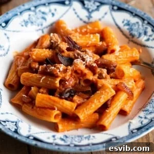 A close up of pasta alla zozzona in a blue and white bowl.