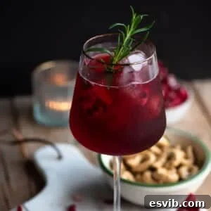 A close-up cropped image of a Pomegranate Spritz, showcasing its inviting deep red color and effervescence, perfect for a festive occasion.