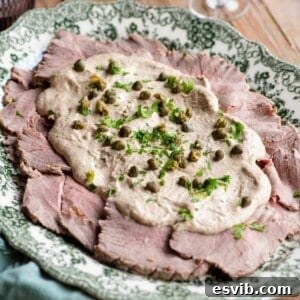 A cropped image of Vitello Tonnato on a serving platter, showing the tender veal and rich sauce.