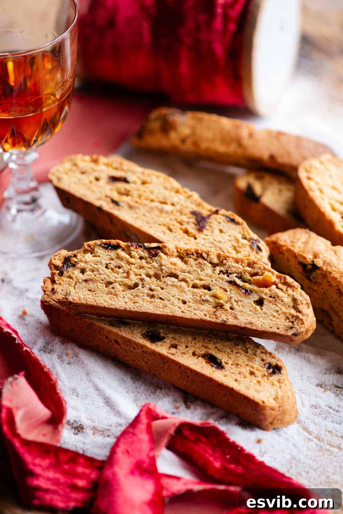 A close up side shot of Panettone Biscotti on a wooden board covered with sugar, showcasing their golden-brown and crispy texture.