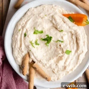 A square image of the creamy white bean dip, garnished with fresh herbs, suitable for social media sharing.