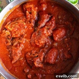 A square cropped image of ragu alla napoletana in a large pot.