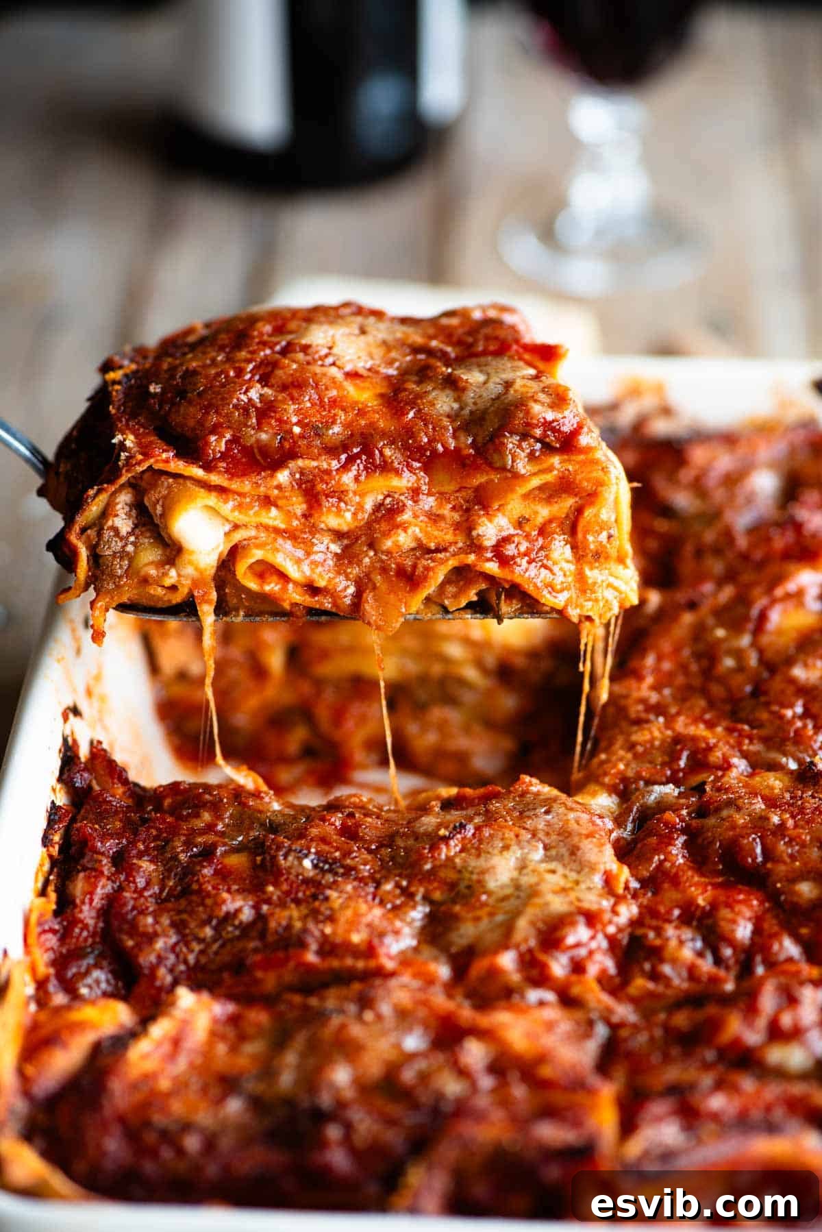 A tantalizing side shot of a perfect slice of Neapolitan lasagna being lifted from a baking dish, revealing its rich, inviting layers.