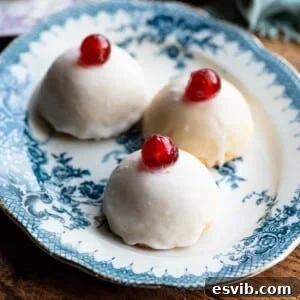 A cropped square image featuring three Minne di Sant'Agata pastries arranged on a blue plate, each crowned with white icing and a single cherry.