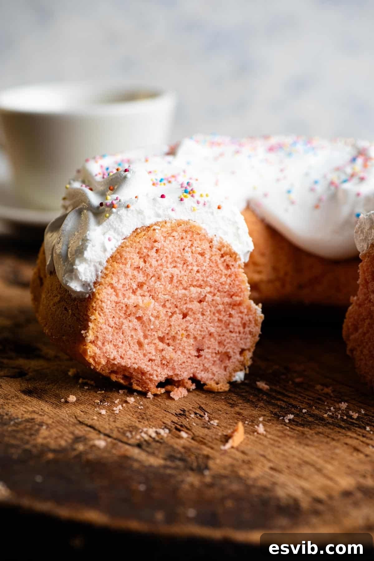 Ciaramicola Umbria's Easter Gem 7 A slice of Italian bundt cake, Ciaramicola, revealing its striking bright pink sponge and fluffy meringue topping, presented on a plate.