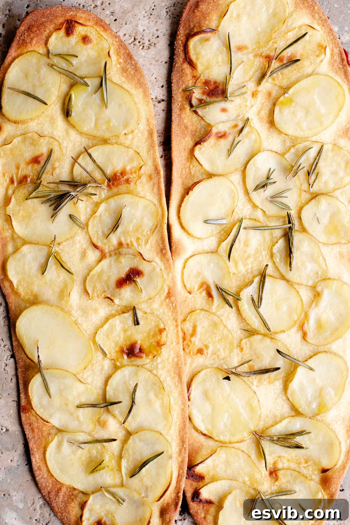 Quick Crispy Pizza Bites 8 Two long and thin pizzas with slices of potato and rosemary on top.