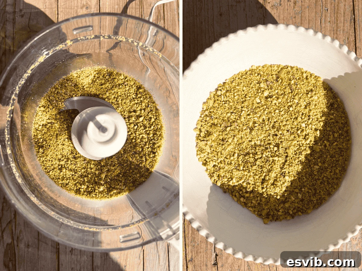 Finely blitzed pistachios in a food processor bowl, resembling coarse crumbs.