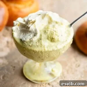 A close up of pistachio granita in a glass bowl with whipped cream on top.