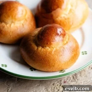 A close up of a Sicilian brioche on a plate that white with green flowers.