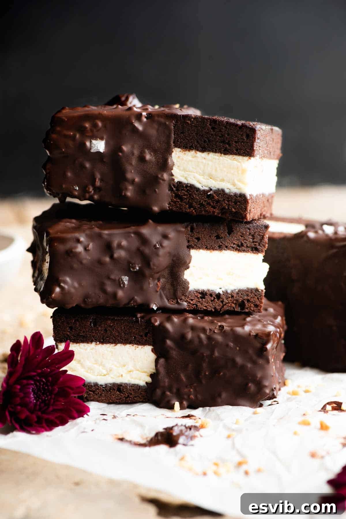 Three perfectly crafted chocolate and vanilla ice cream sandwiches, stacked invitingly on a travertine surface, set against a chic black background.