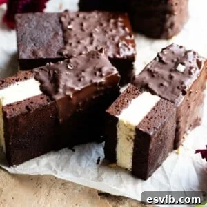 Three beautifully presented ice cream sandwiches featuring a rich chocolate sponge base and creamy vanilla ice cream, arranged on baking parchment.