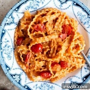 Pasta ribbons in a creamy sundried tomato sauce in a blue and white bowl.