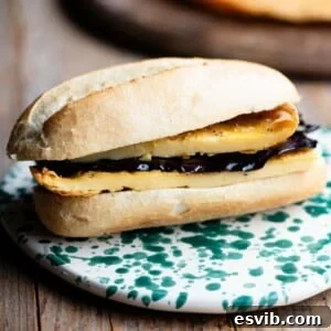 A close up of a roll filled with a chickpea flatbread and marinated eggplant, showing the delicious textures.