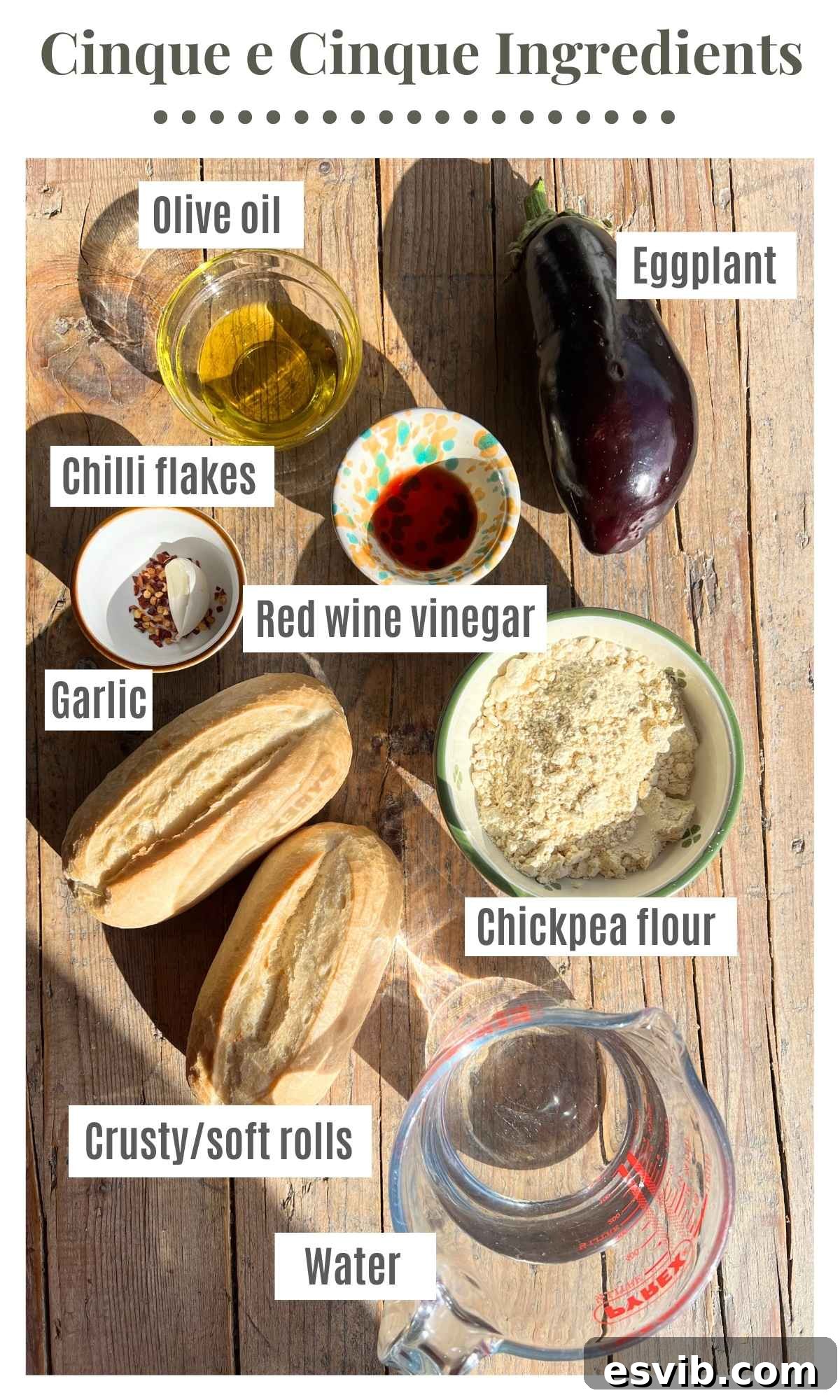 All the fresh ingredients needed to make a 5x5 Livornese sandwich sitting on a rustic wooden background, including chickpea flour, fresh eggplant, garlic, chili, olive oil, and crusty rolls.