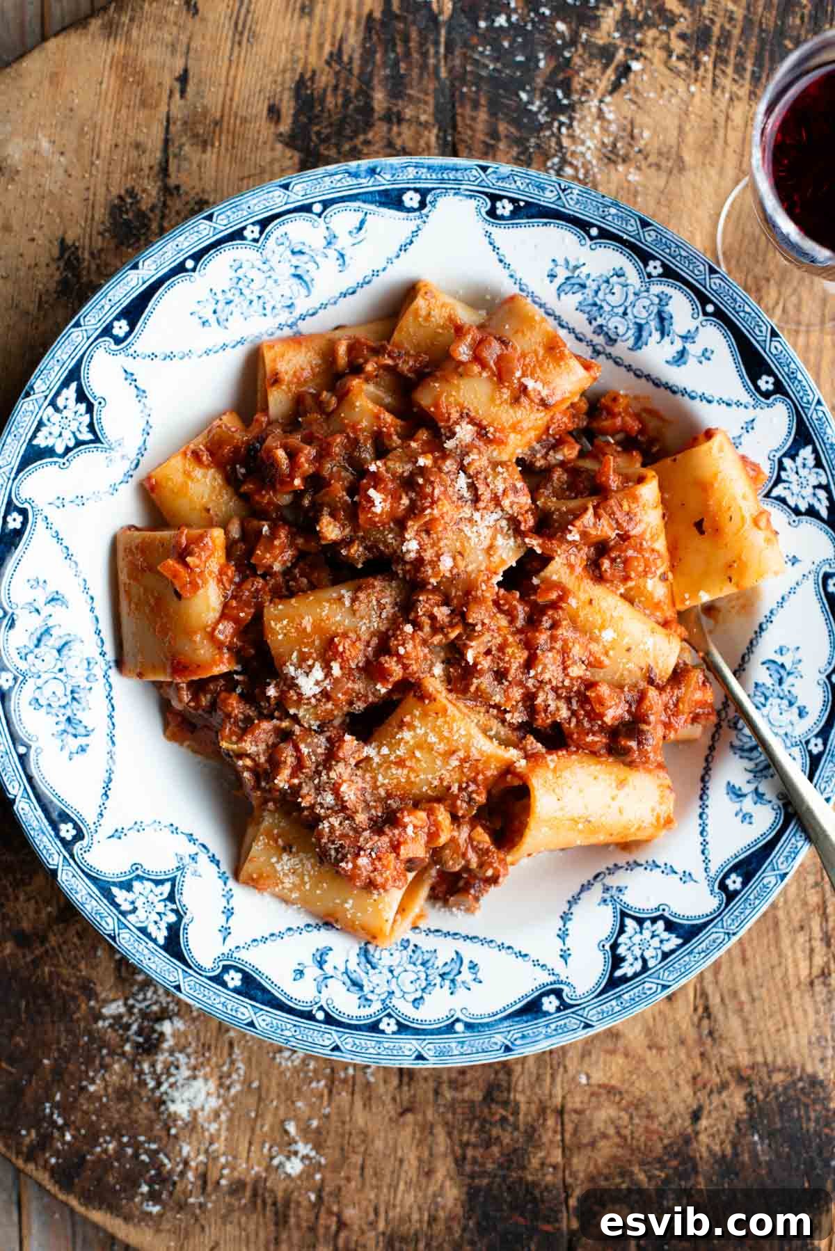 Artisan Piedmontese Hazelnut Ragu 2 A blue and white vintage style bowl with paccheri and hazelnut ragu, garnished with fresh herbs.