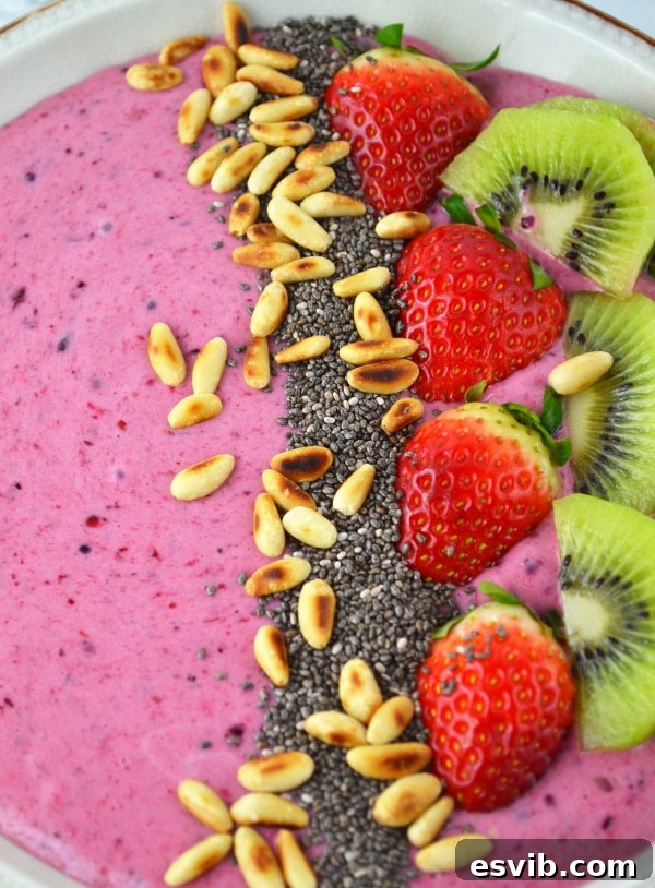 This Berry Banana Smoothie Bowl recipe is filled with delicious berries, banana, honey and is topped with chopped fruit and toasted pine nuts. www.insidetherustickitchen.com Another perspective of the Berry Banana Smoothie Bowl, highlighting the fresh ingredients and inviting presentation.