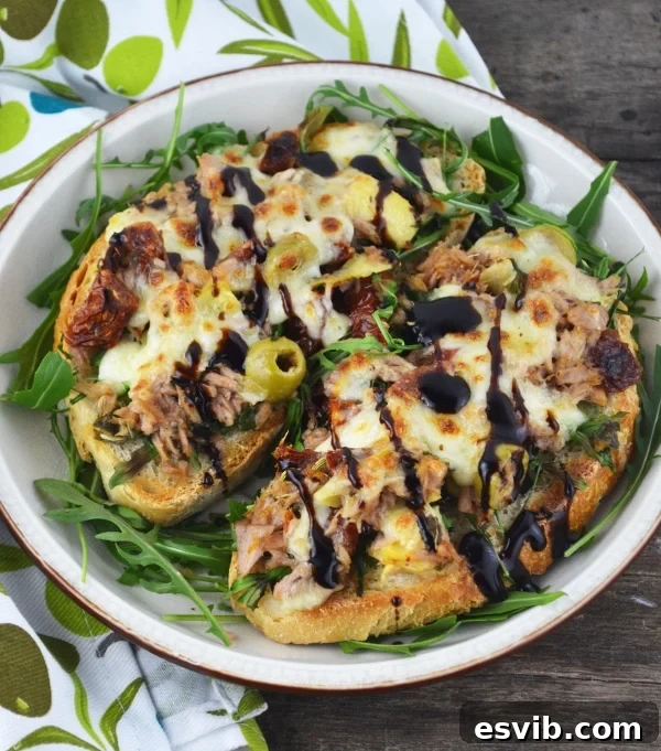 Mediterranean tuna melt ingredients mixed in a bowl, showing artichokes, sun-dried tomatoes, and tuna