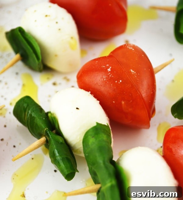 Valentine's Caprese Skewers with heart-shaped tomatoes, perfect for a romantic appetizer. www.insidetherustickitchen.com