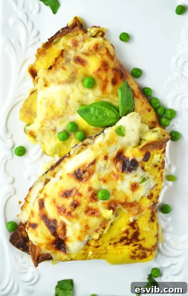 Delicious Crespelle with Ricotta, Peas, Ham, and Fontina Cheese Sauce – a perfect Italian dinner. Golden-brown Crespelle (savory crepes) baked with a delicious Fontina cheese sauce, ready to be served