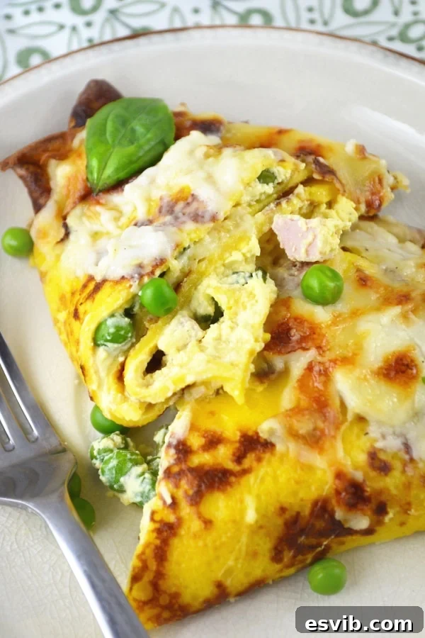 Baked Crespelle with Ricotta, Peas, Ham, and a Creamy Fontina Cheese Sauce – a must-try Italian recipe. Close-up of baked Crespelle (savory crepes) revealing a bubbly, golden Fontina cheese sauce and a glimpse of the rich filling.
