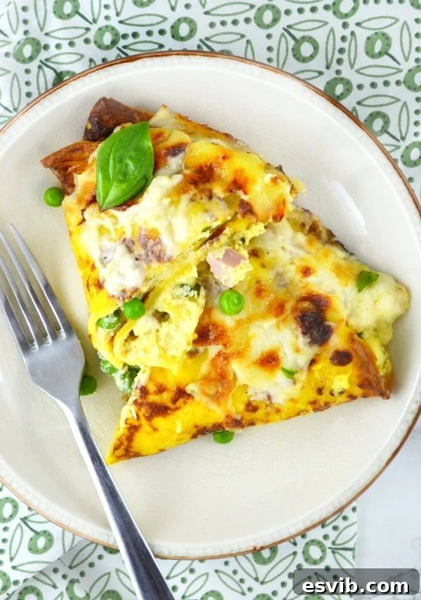 Prepare Crespelle in advance: savory crepes filled with ricotta, peas, and ham, ready for baking. Assembled Crespelle (savory crepes) neatly folded in a baking dish, ready for the Fontina cheese sauce and oven.