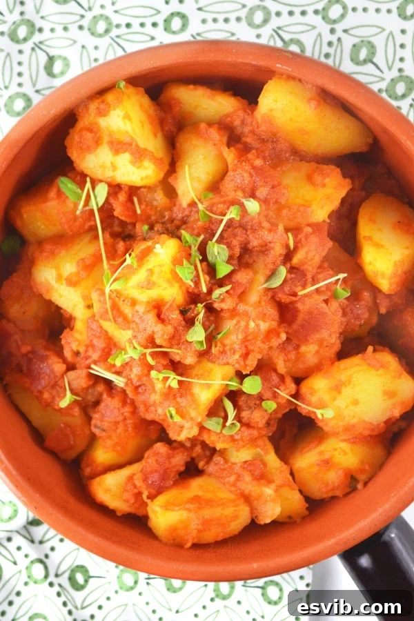 Patate Rifatte - an Italian potato side dish served in a bowl, garnished with fresh herbs