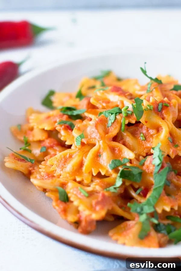 A delicious and simple farfalle pasta with pancetta recipe with fresh chili, garlic and a dash of cream. This simple pasta dish makes a great quick weeknight meal that's delicious eaten hot or cold. Italian pasta recipes inside the rustic kitchen A pan with simmering farfalle pasta sauce, made with pancetta, chopped tomatoes, chili, and garlic, ready to be combined with cooked pasta.
