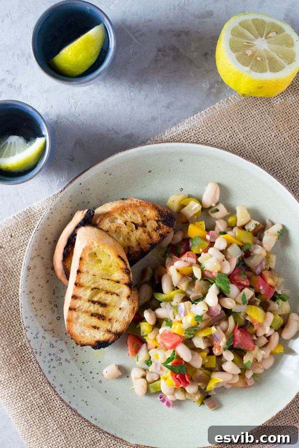 Warm Easy Bean Salad with Eggplant, Tomato, Garlic, and Fresh Herbs A vibrant warm easy bean salad with yellow pepper, eggplant, tomatoes, garlic, and fresh herbs, served alongside crusty char-grilled bread. Perfect for a quick and delicious meal. insidetherustickitchen.com