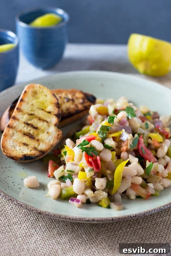 Warm Easy Bean Salad: Fresh and Flavorful A beautifully presented warm easy bean salad, highlighting the roasted eggplant, fresh tomatoes, and herbs, ready to be served. A healthy and quick meal idea. insidetherrustickitchen.com