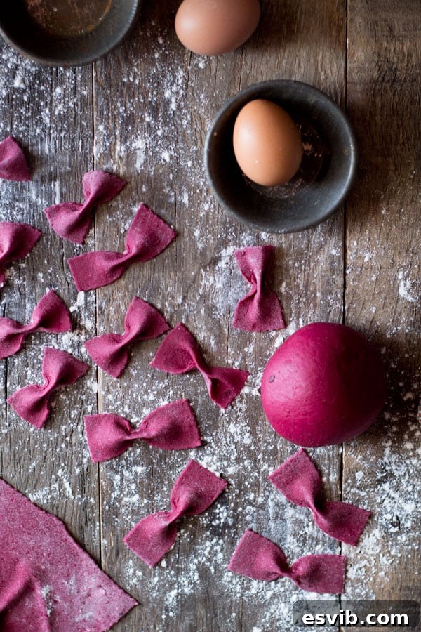 Rolling and shaping homemade beetroot pasta. Beetroot pasta dough being rolled out and cut into shapes.