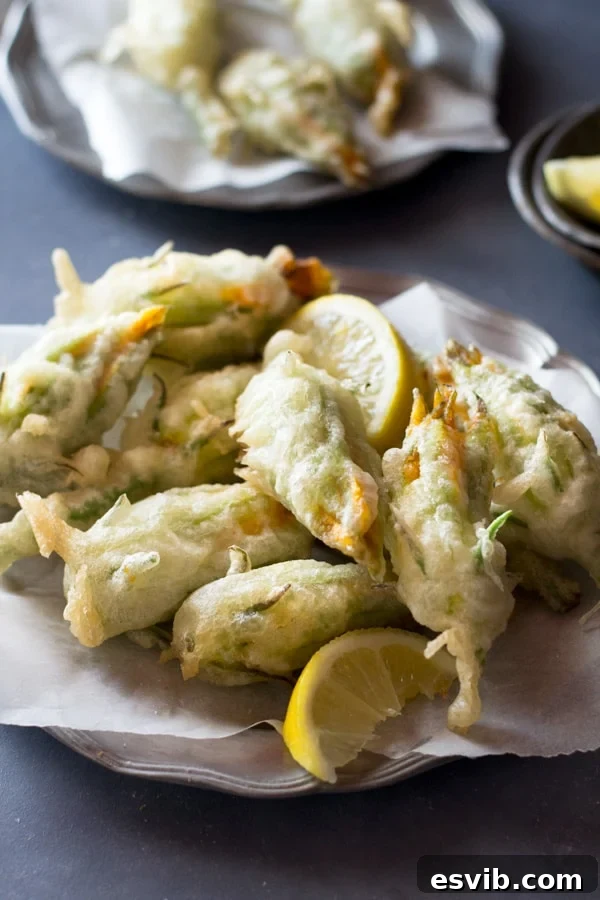 Crispy fried zucchini flowers stuffed with ricotta, chili flakes and lemon inside a rustic kitchen