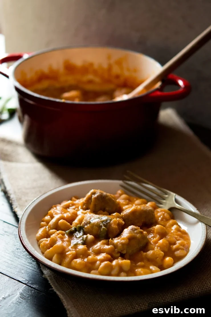 A close-up view of the delicious Tuscan bean stew with sausages, ready to be enjoyed, with a fork nearby.