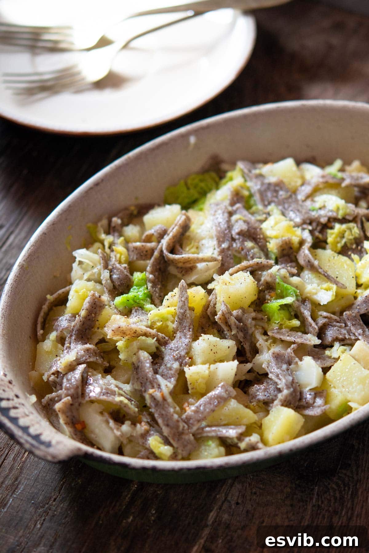 Pizzoccheri pasta in a baking dish with potatoes, cabbage and melted Fontina cheese, ready to serve