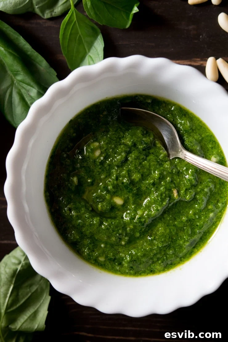 Close-up shot of freshly made basil pesto in a bowl, showcasing its rich green color and smooth texture.