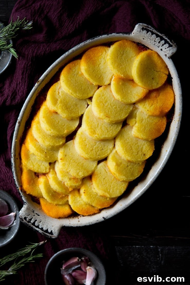 Baked polenta with sausage and beef ragu in a baking dish