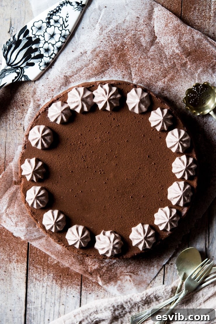 An overhead shot of a luxurious no-bake chocolate cheesecake topped with delicate ricotta frosting, sitting on baking parchment, ready to be served.