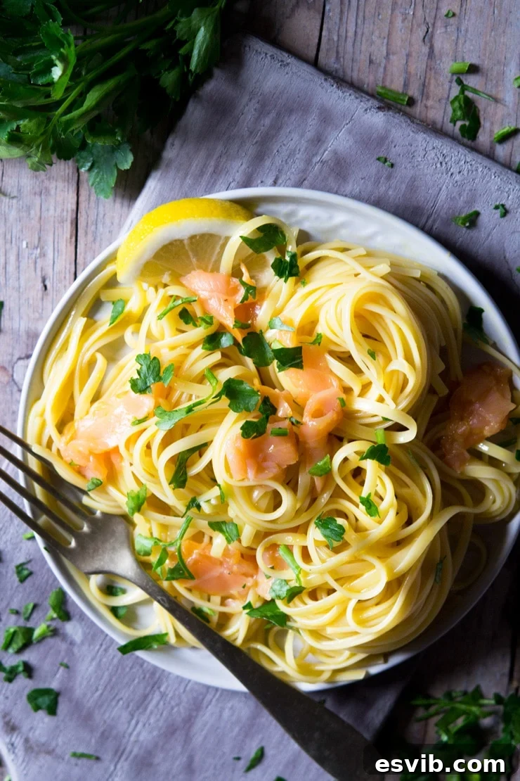 a close up of smoked salmon pasta on a plate and sitting on a wooden surface