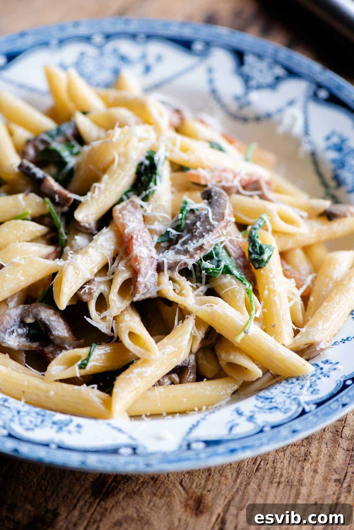 Crispy Guanciale, Mushroom & Spinach Pasta 6 A close up of mushroom spinach pasta in a blue and white bowl.