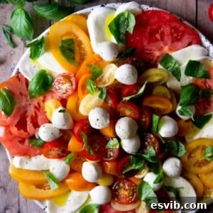 Easy Fresh Delicious Classic Caprese Salad 2 An overhead shot of a Caprese salad with vibrant coloured tomatoes and creamy mozzarella, ready to be served.