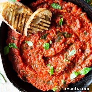 A close-up overhead shot of tomato sauce in a skillet with two slices of char-grilled bread at the side.