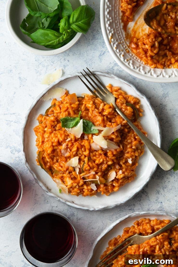 Creamy Tomato Risotto with Parmesan and Basil An overhead shot of creamy tomato risotto on a plate topped with freshly grated parmesan and vibrant basil leaves, ready to be enjoyed.