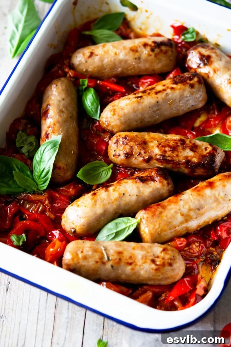 A close up of an Italian sausage bake with tomatoes and basil leaves