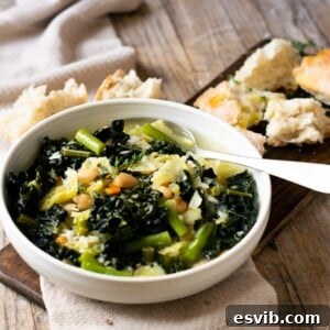 A bowl of Tuscan minestrone soup on a wooden surface with bread